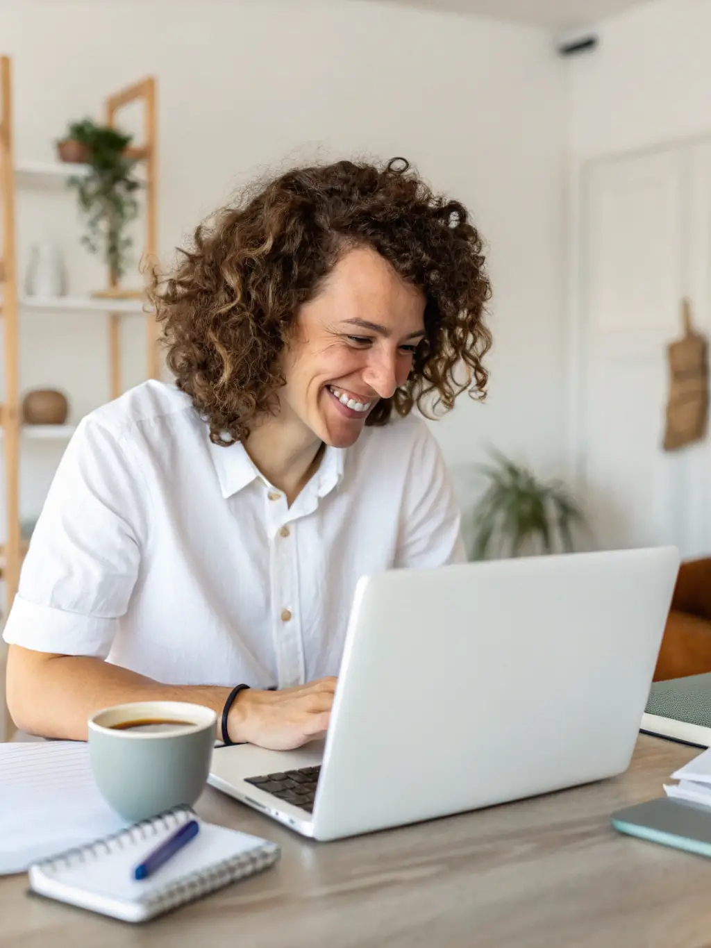 A vibrant image of a business owner happily checking increased social media notifications on a smartphone, with a laptop displaying a website dashboard in the background, representing improved online presence for small businesses.